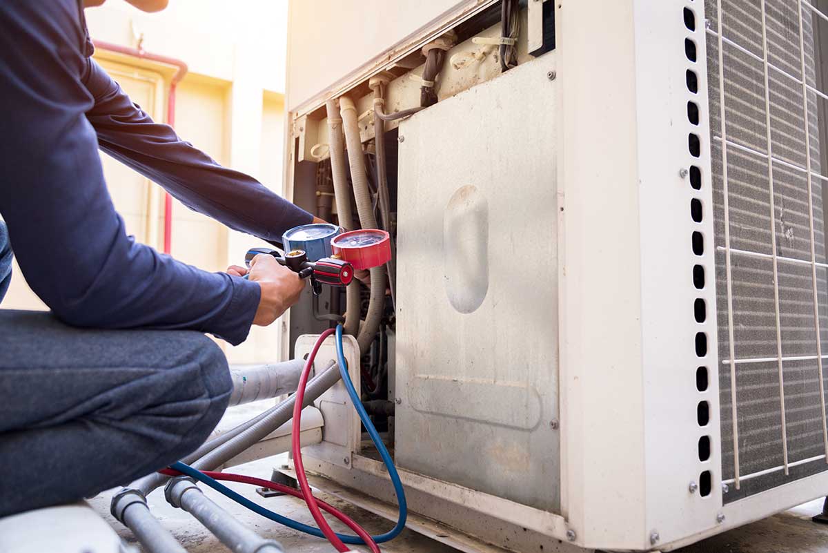 technician inspecting air conditioner during repair in Riverside
